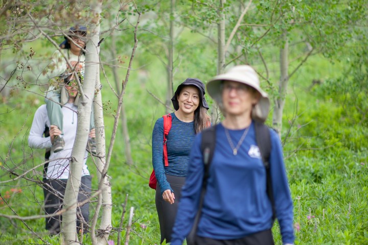 a young boy standing next to a tree