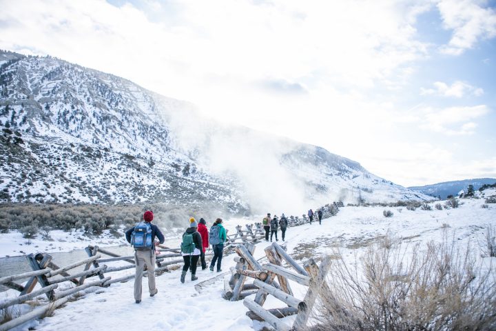 a group of people standing on top of a snow covered mountain