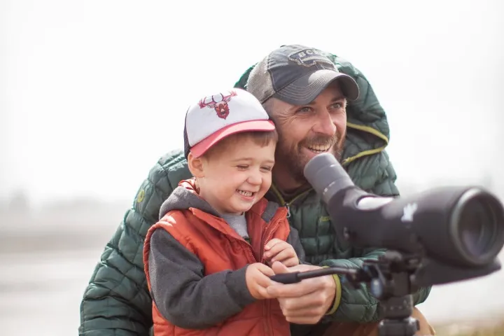a little boy wearing a helmet and holding a gun