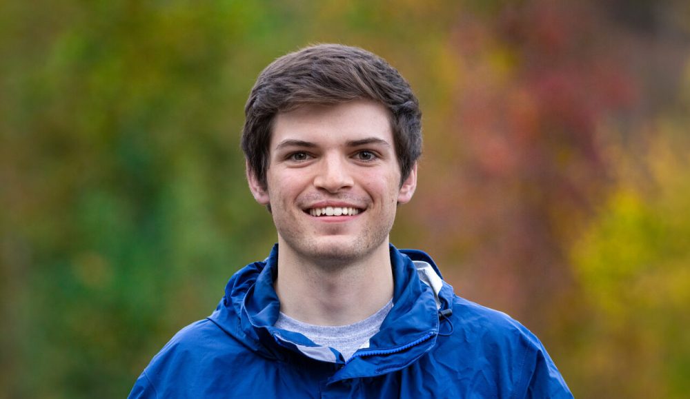 a man wearing a blue shirt and smiling at the camera
