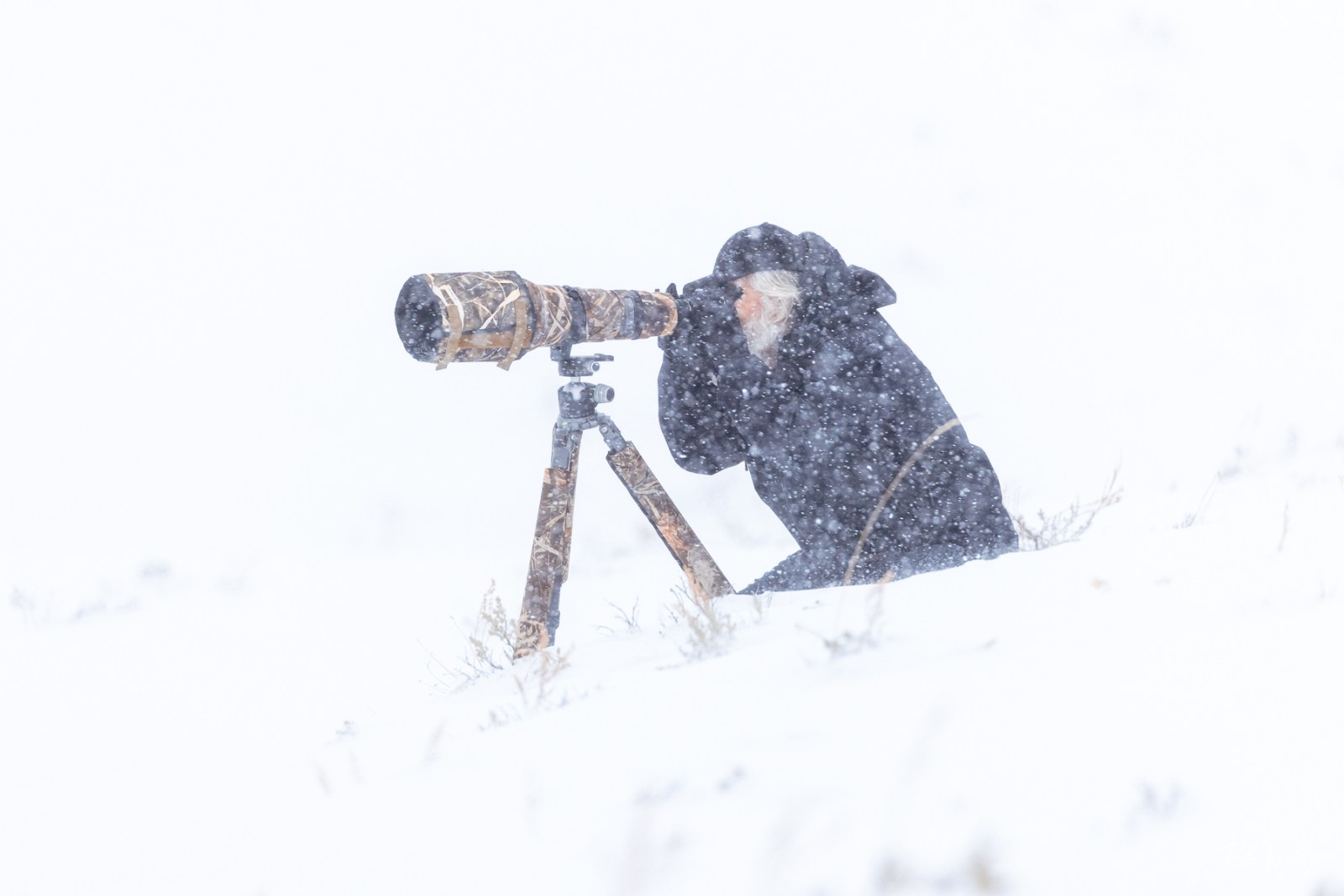 a man riding a snowboard down a snow covered slope