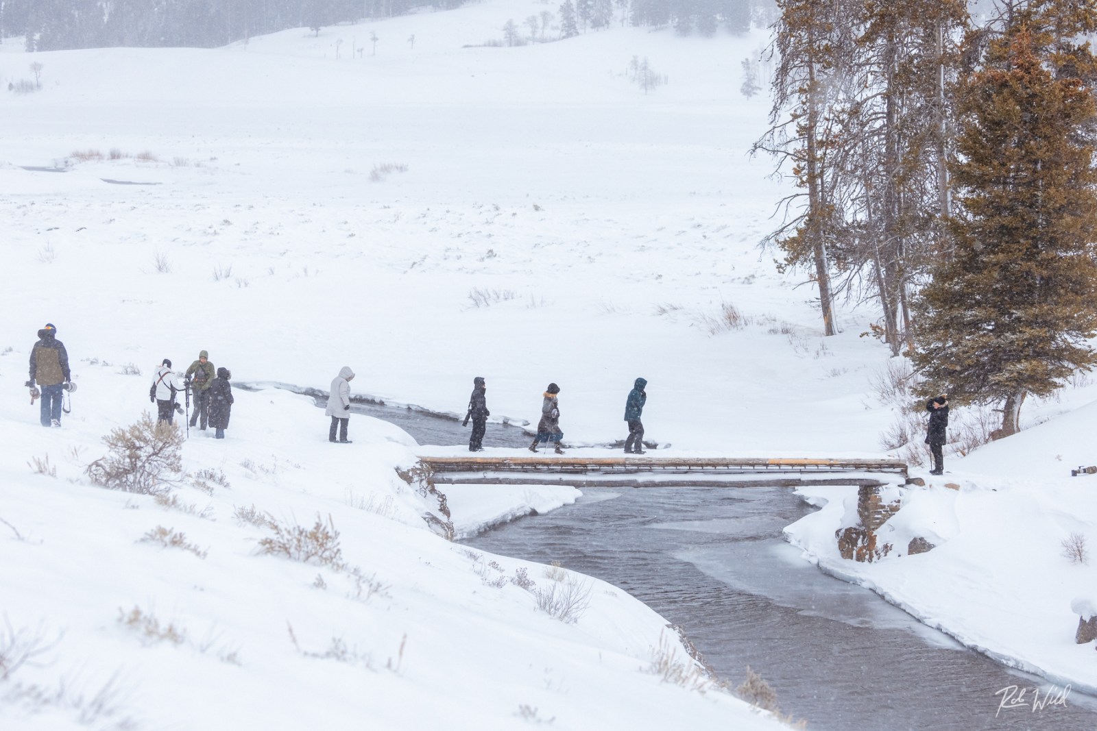 a group of people riding on top of a snow covered slope