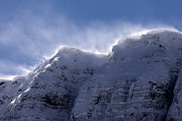 a man riding skis down a snow covered mountain