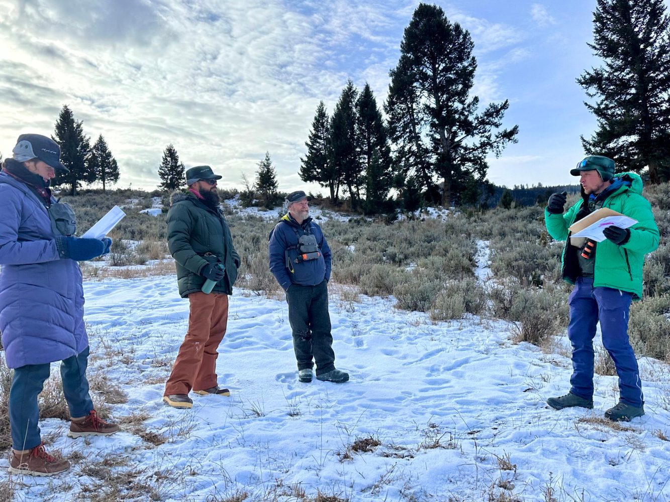 a group of people standing on top of a snow covered field