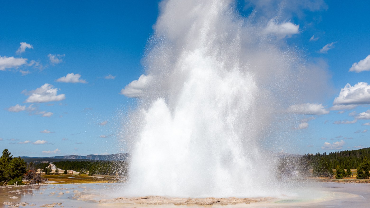 Great Fountain Geyser in eruption with magnificent reflections in the surrounding terraces