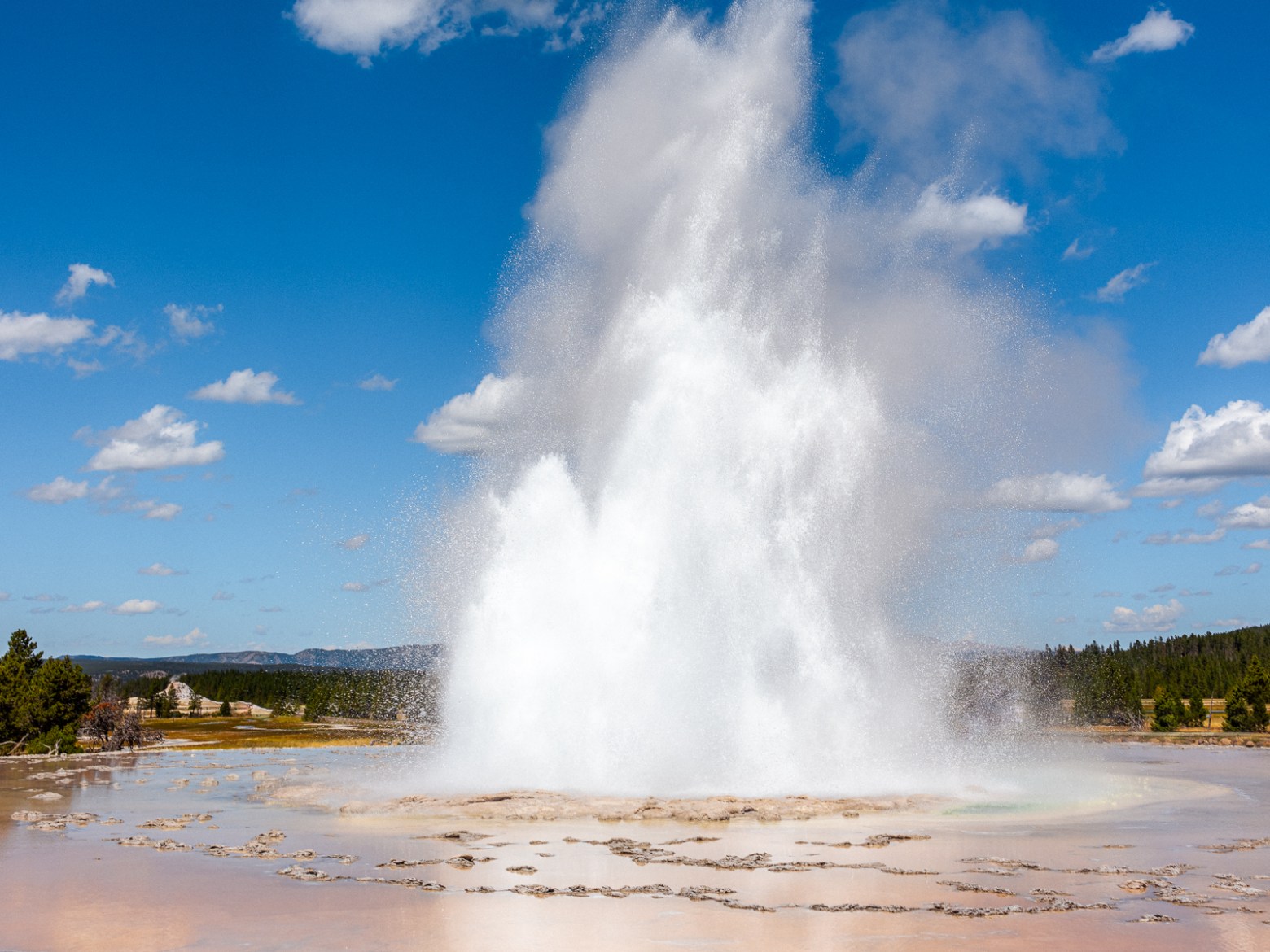 Great Fountain Geyser in eruption with magnificent reflections in the surrounding terraces