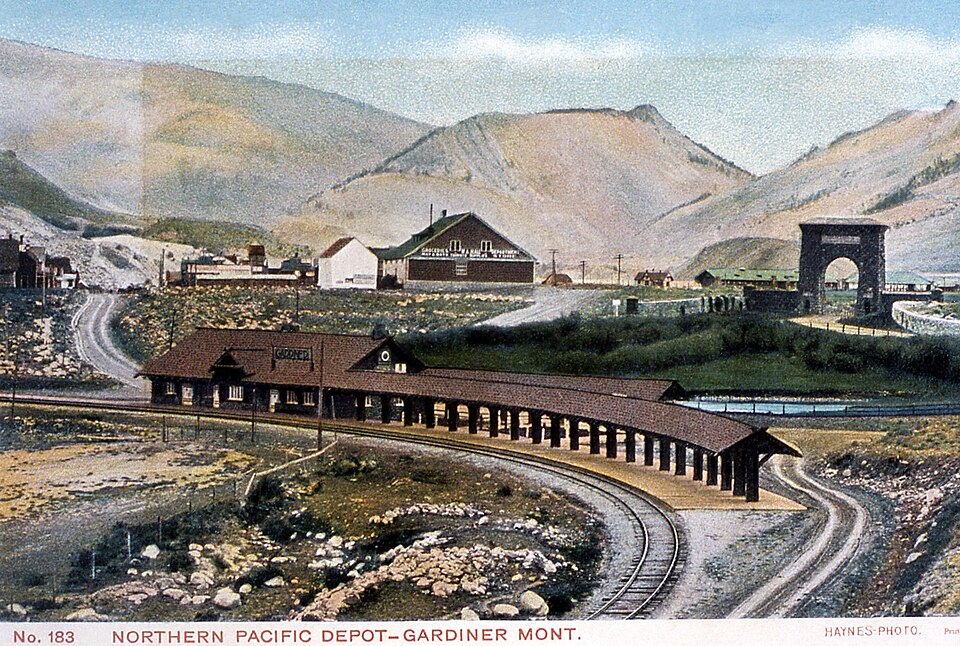 Vintage postcard of a scenic train depot with mountains in Gardiner, Montana.